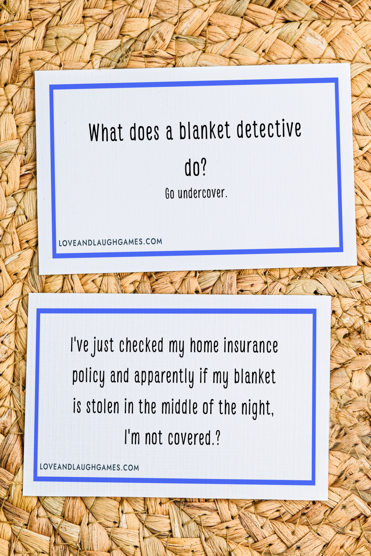 Two white cards with blue borders on a woven surface; one card reads, What does a blanket detective do? Go undercover. The other card is a joke about a blanket not being covered by home insurance.